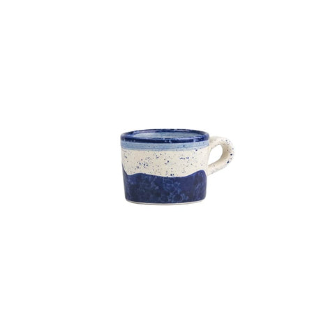 A hand painted wave ceramic espresso cup with a speckled white and navy blue design and smooth handle