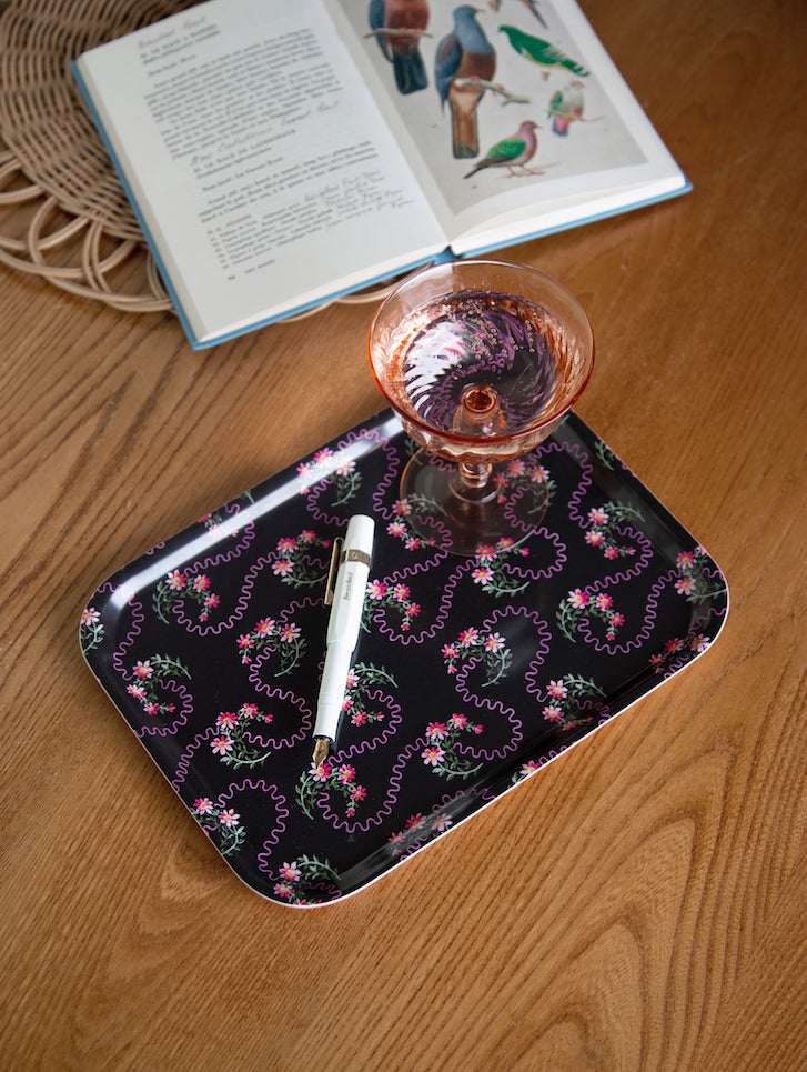 Black rectangular waves of love tray with delicate pink and green floral pattern and wavy outlines around blossoms
