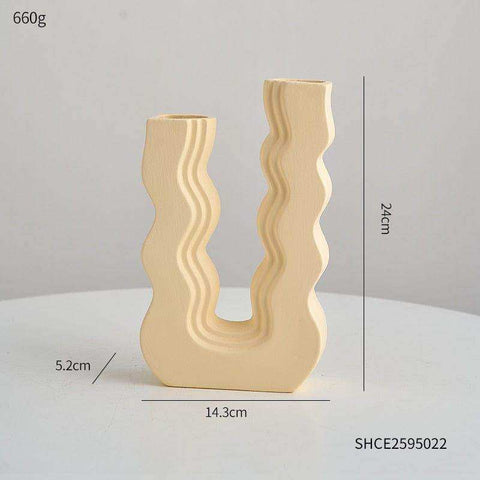 Cream-colored ceramic wavy wonder vase with u-shaped design and two vertical openings for decoration