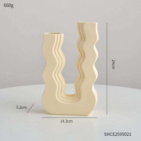 Cream-colored ceramic wavy wonder vase with u-shaped design and two distinct openings for decorative use