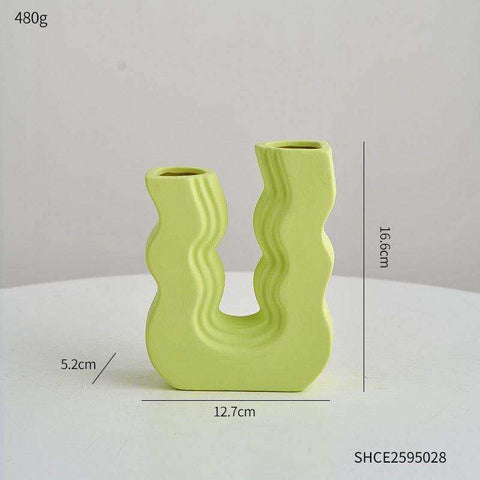 A lime green ceramic wavy wonder vase with u-shaped design and two openings perfect for modern decor