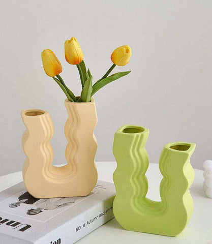 Cream-colored ceramic wavy wonder vase with sculptural design holding bright yellow tulips for home decor