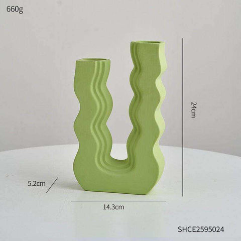 A modern light green ceramic wavy wonder vase with u-shaped design and two separate openings
