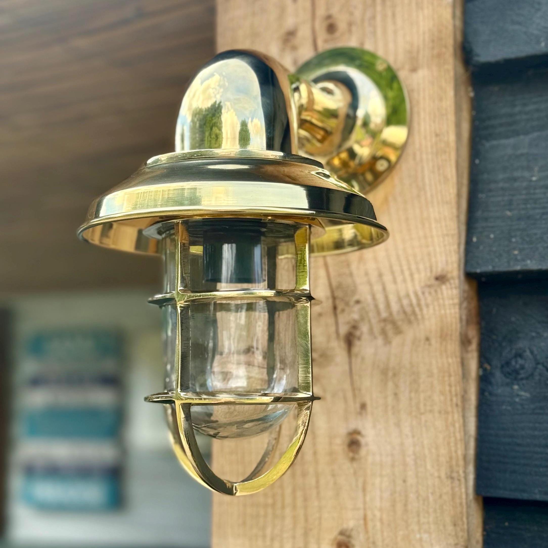 Wells solid brass wall light with nautical clear glass cage and polished finish perfect for bathroom wall light use