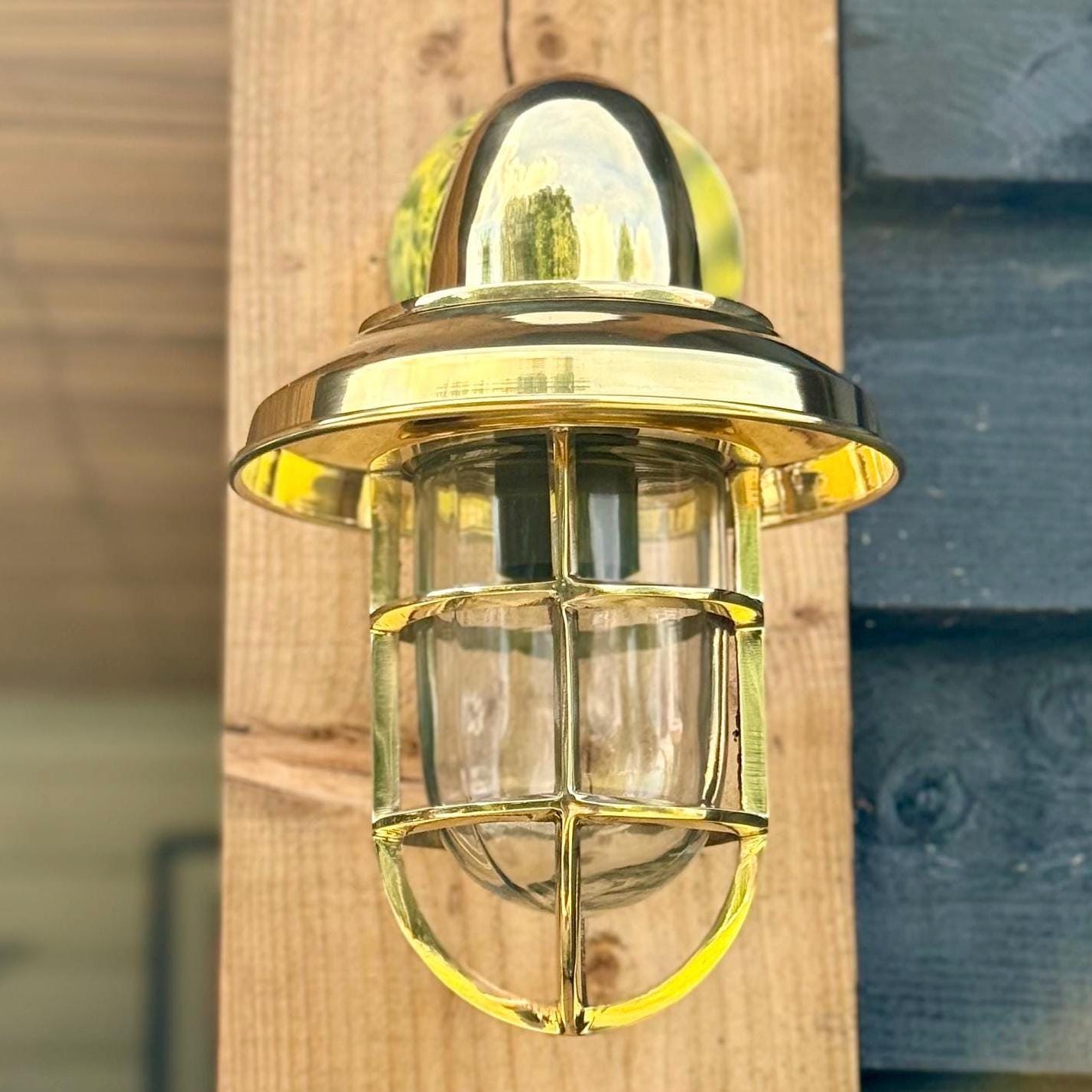 Solid brass wells bulkhead wall light with domed top and clear glass cage for outdoor and bathroom wall light use