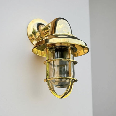 Brass nautical style solid brass wall light with clear glass and protective cage for outdoor and bathroom use