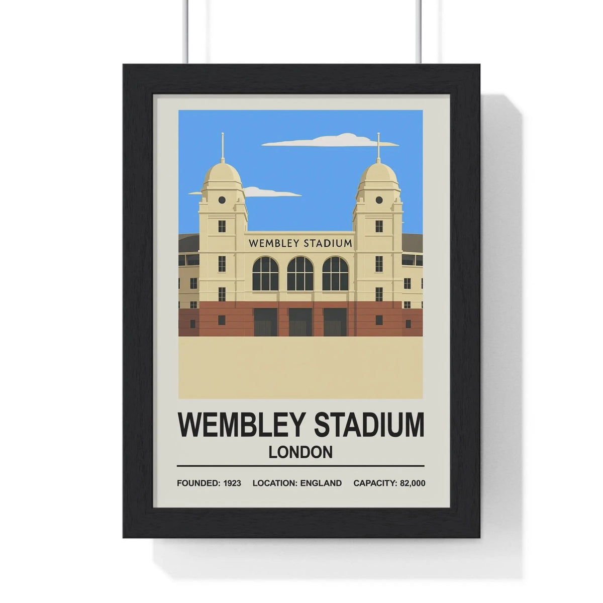Black-framed wembley stadium poster print with beige and red stylized illustration against blue sky background