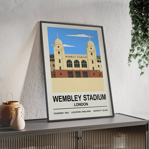 A framed wembley stadium poster print with minimalist beige and red design against a blue sky background