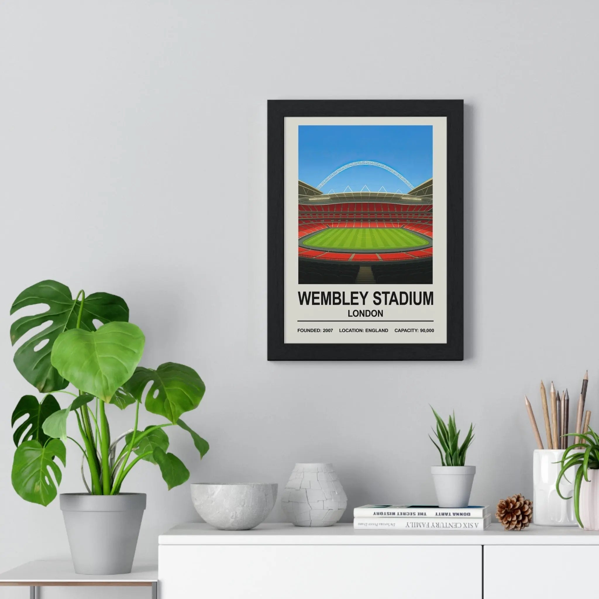 Black-framed wembley stadium poster featuring a stylized illustration of the iconic arch and green pitch under blue sky