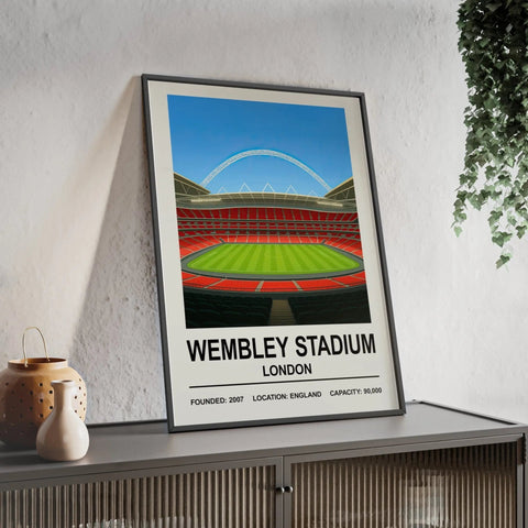 A framed wembley stadium poster with vibrant red seating and green grass under a blue sky illustration