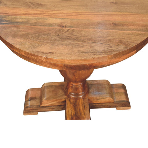 Wentworth round dining table with a rustic round wooden top and intricate carved base in warm natural finish