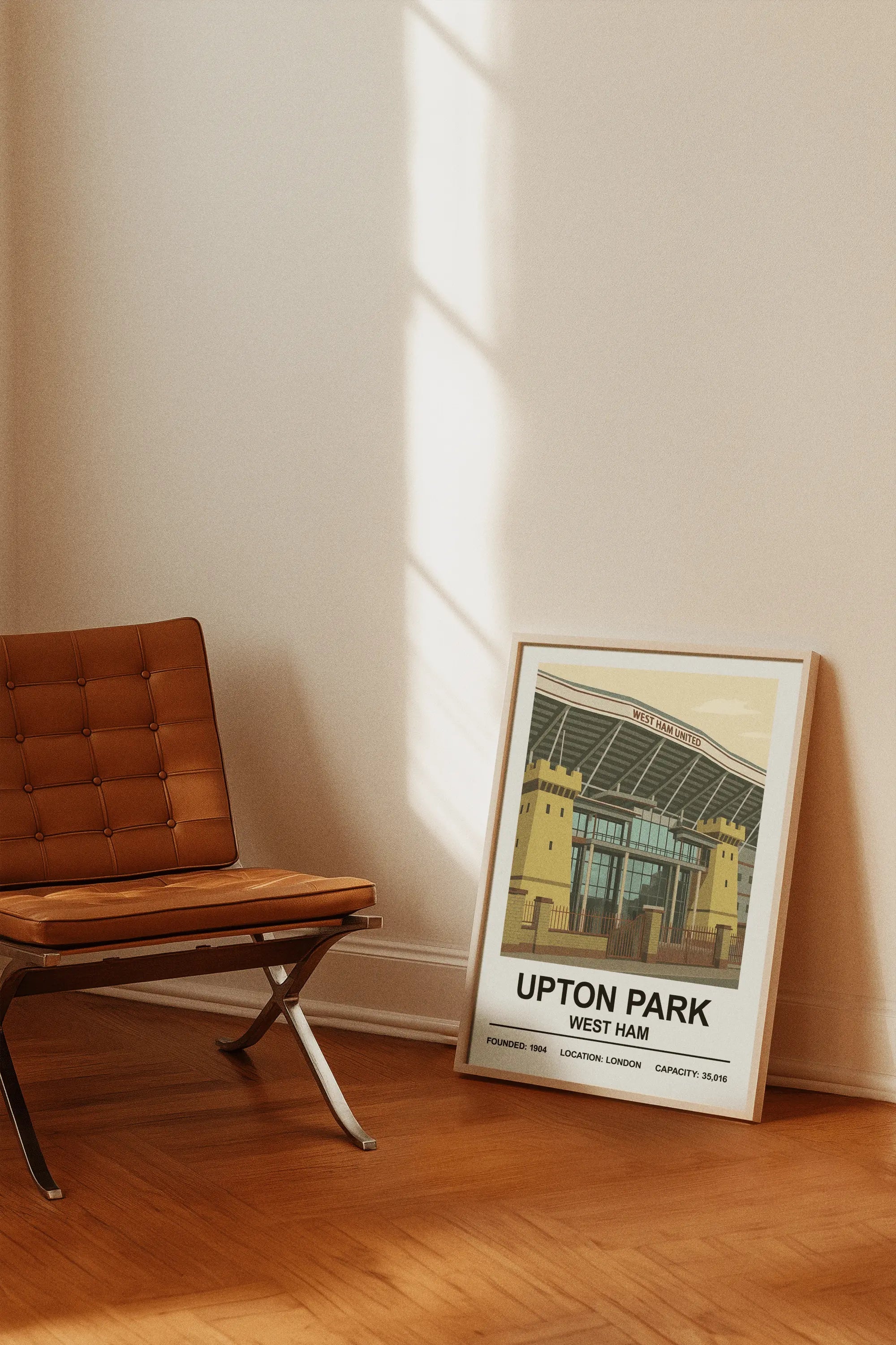A framed vintage-style west ham stadium print featuring a beige and green upton park illustration with black text