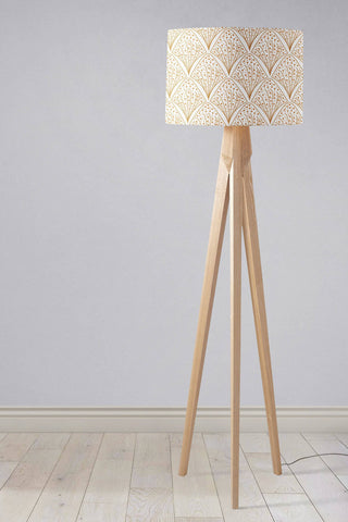 A beige table lamp with a gold contemporary geometric fan pattern on a white and gold 12 inch diameter lampshade