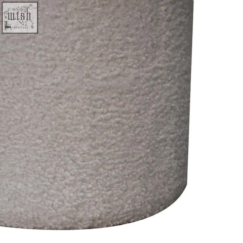 White boucle mushroom footstool with a cylindrical gray textured lampshade and plush bumpy surface