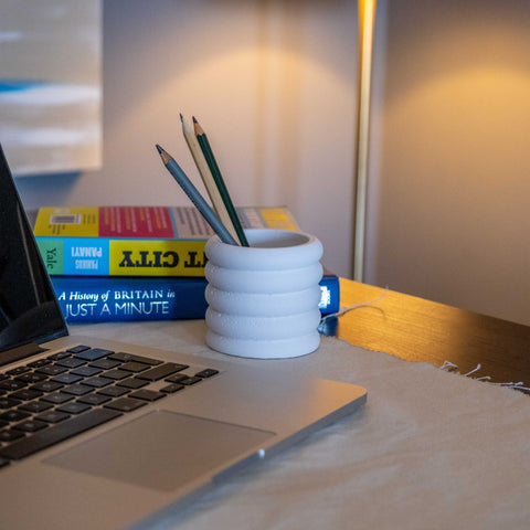 White concrete fold pot with a stacked ring design made of white concrete used as a ceramic pencil holder