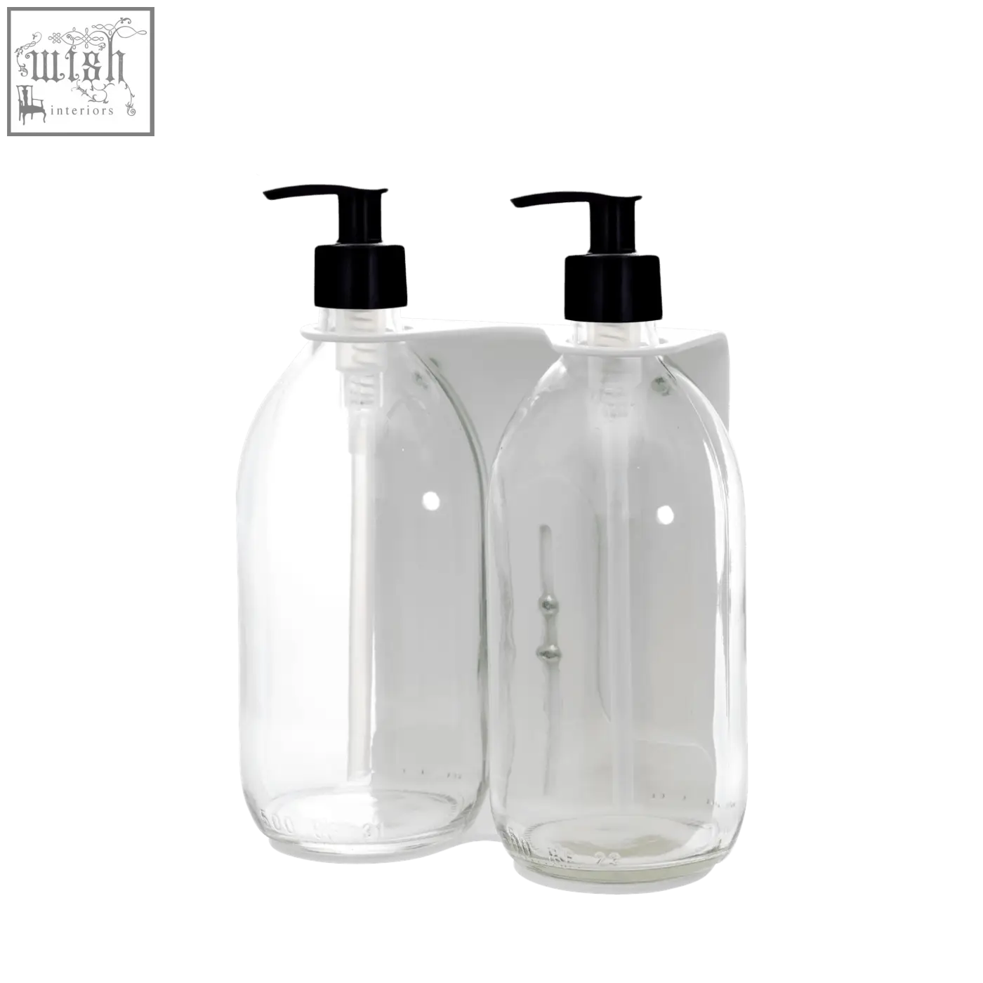 White wall-mounted soap dispenser with clear glass bottles and black pump tops on a white wall bracket