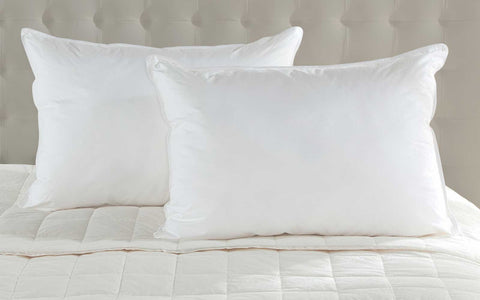 Two plush white duck down pillowcases on bed showing soft fabric and comfy sleeping style