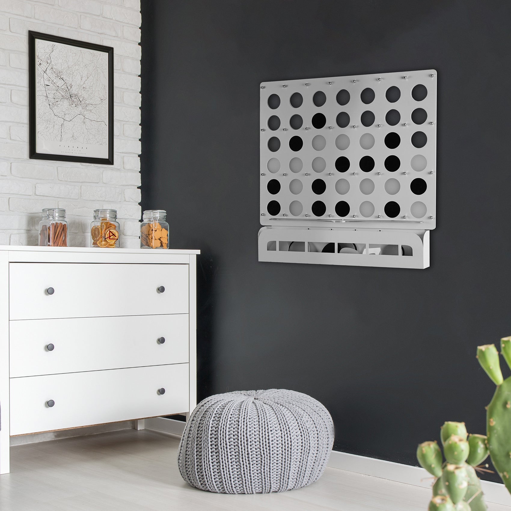 Silver metal connect four game board with black and gray pegs mounted on wall for indoor play age range 6 and up