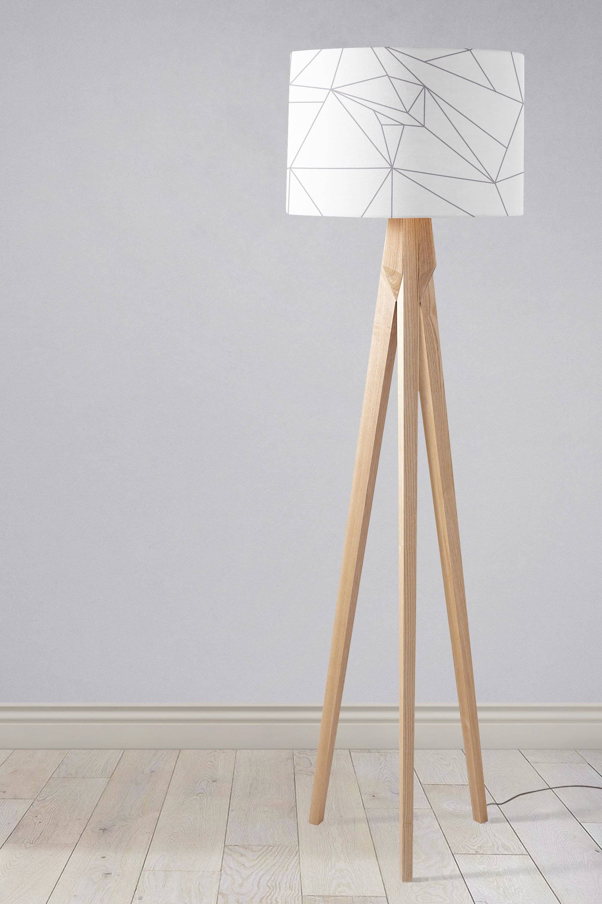 Minimalist tripod floor lamp with light wood lamp base and white table lamp shade with grey geometric lines design