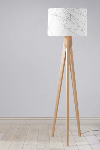 Minimalist tripod floor lamp with light wood lamp base and white lampshade featuring grey geometric lines design