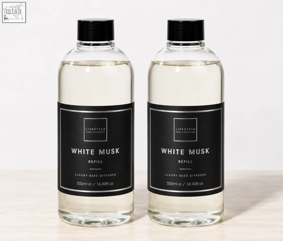 Two clear glass bottles with black caps containing 500ml white musk premium xxl reed diffuser refill for home collection premium