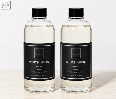 Two clear glass bottles with black caps containing 500ml white musk premium xxl reed diffuser refill for home collection premium