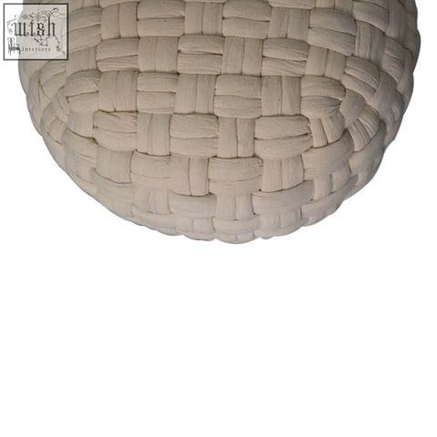 Beige woven fabric sphere with textured interlaced pattern on a white tube footstool for stylish seating