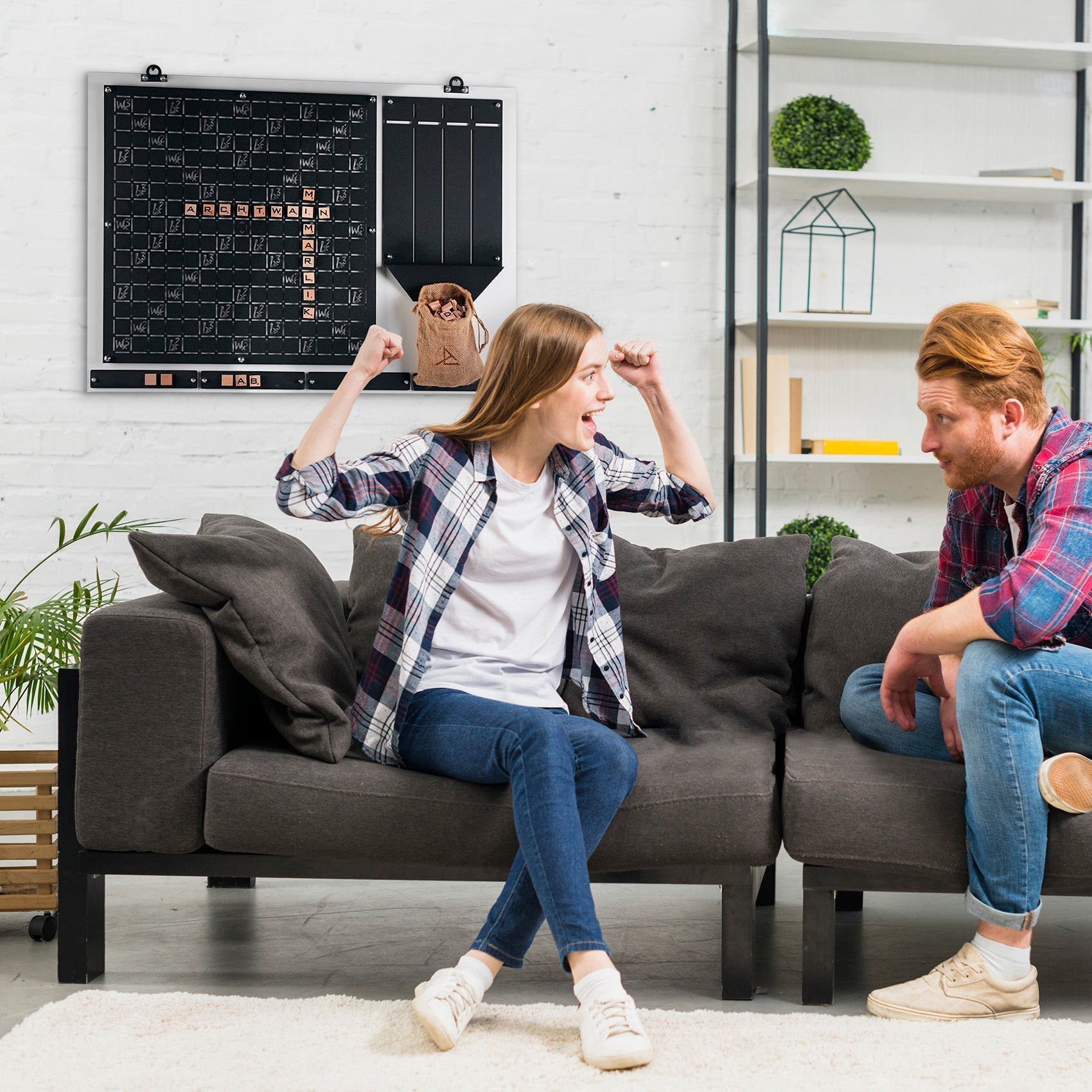 Gray fabric couch with dark gray cushions and black legs perfect for relaxing after playing the words wall game for all ages
