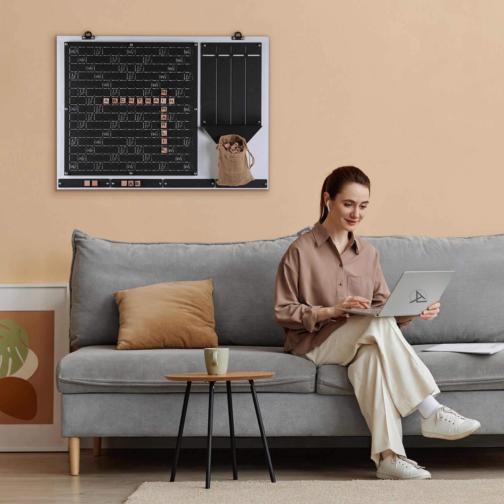A sleek silver laptop with a minimalist design and subtle logo used by the player for the words wall game age range play