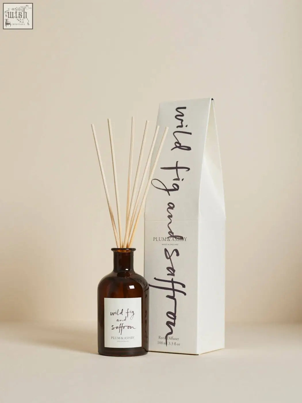 Brown glass wild fig reed diffuser with light wooden reeds and minimalist white label for consistent fragrance throw using vegetable oil