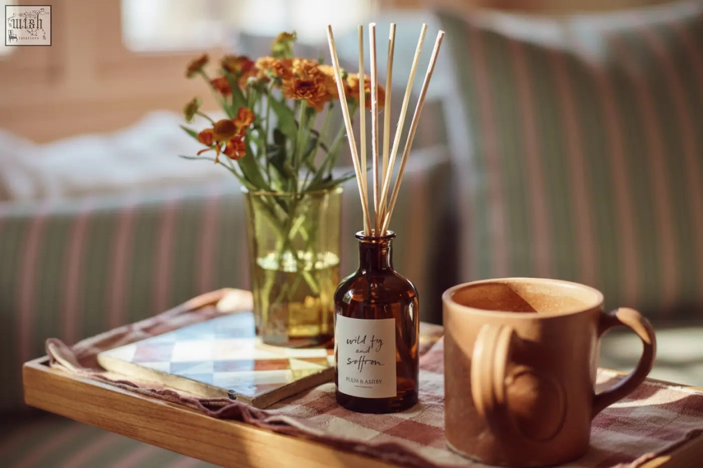 A dark amber glass wild fig reed diffuser with wooden reeds for consistent fragrance throw using vegetable oil