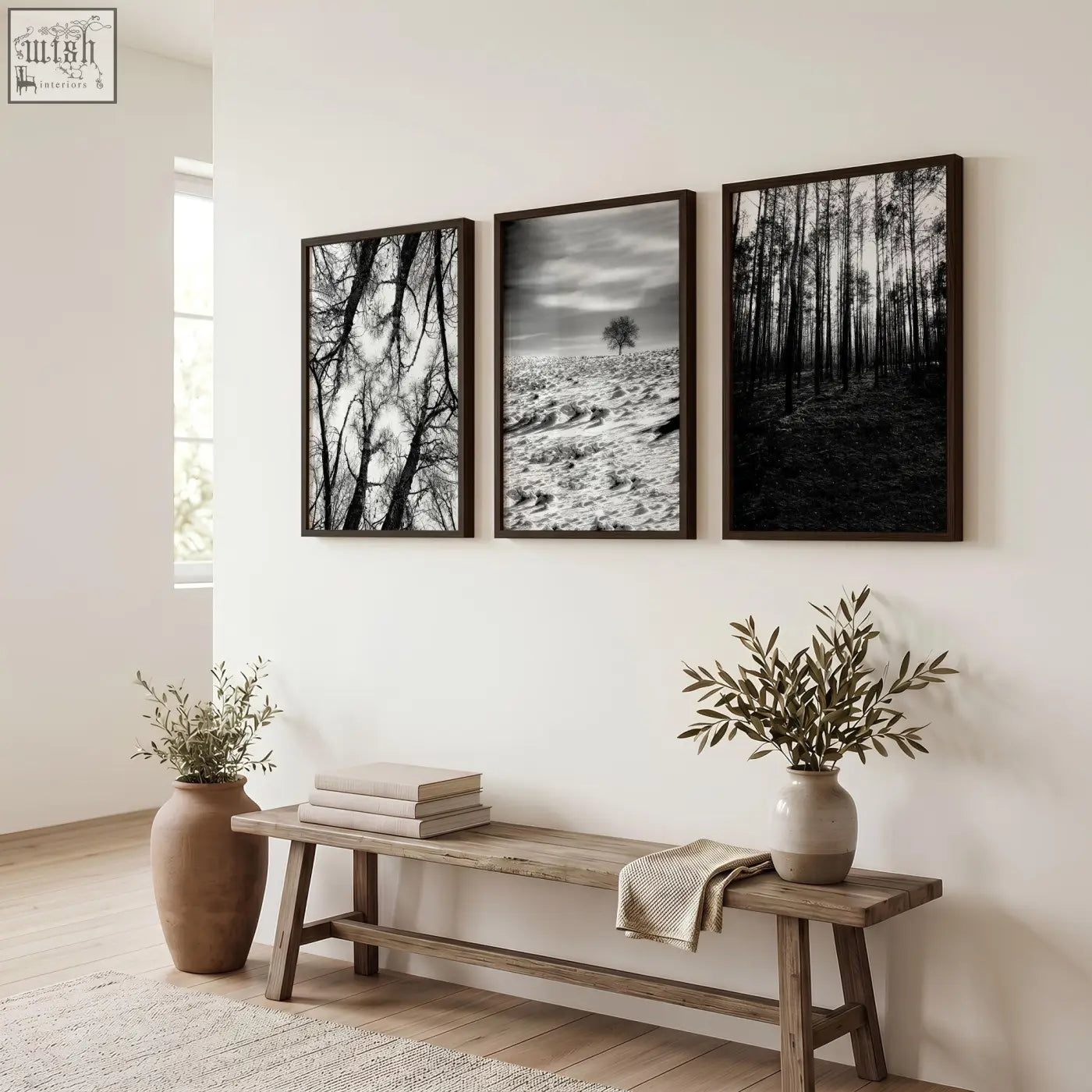 Three black and white wildlife wall art prints with dark wooden frames hang above a rustic bench on a white wall