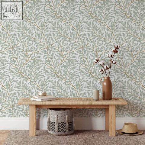 Brown ceramic vase holding cotton stems in a living space with traditional paper willow bough william morris wallpaper