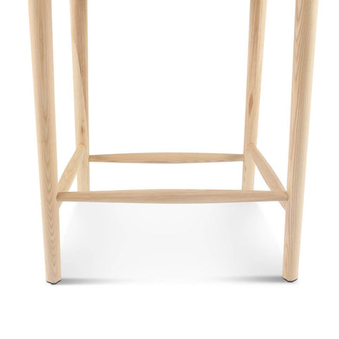 Light-colored wooden legs of wishbone bar stool black ash with natural grain and minimalist design bar stools