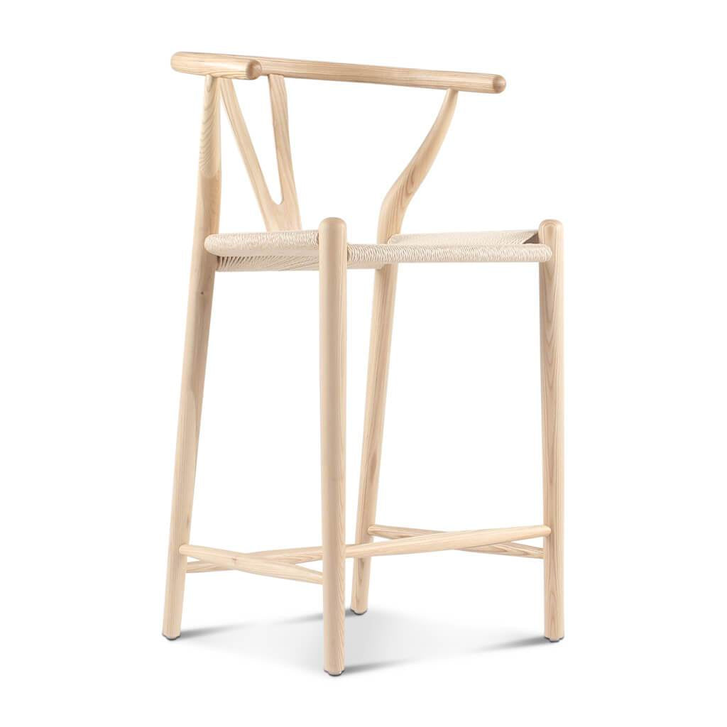 Light-colored wooden wishbone bar stool with woven seat and y-shaped backrest ideal for home bar seating