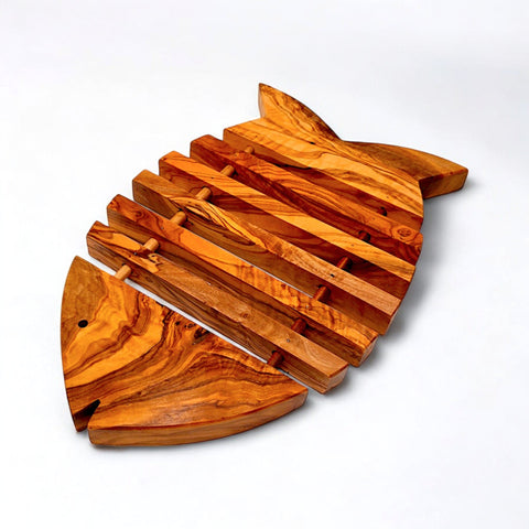 Wooden fish shaped pan coaster in olive wood with warm golden brown finish and natural grain patterns for kitchen use