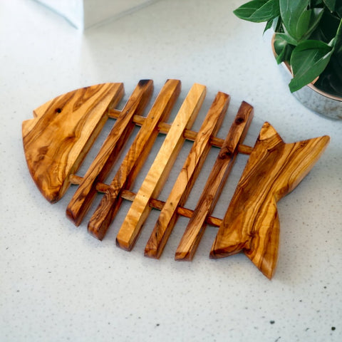 Rustic fish shaped olive wood pan coaster with natural grain and warm brown tones perfect for kitchen use