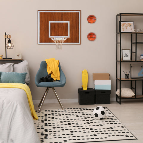 Wooden single hoop walnut with white rim and net mounted on wall above blue chair for indoor basketball play