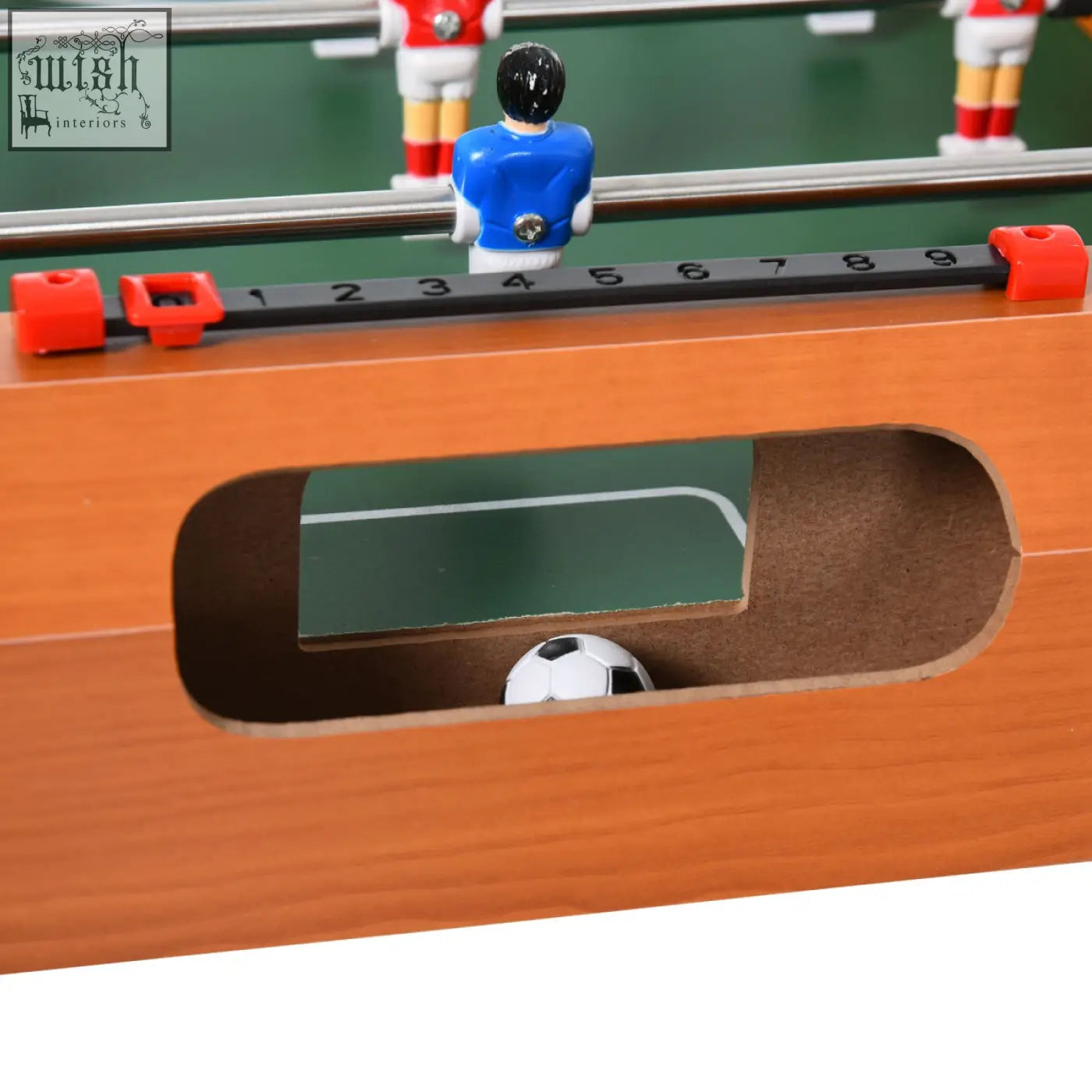A blue and white foosball player figure with black hair on a wooden football table for game room fun