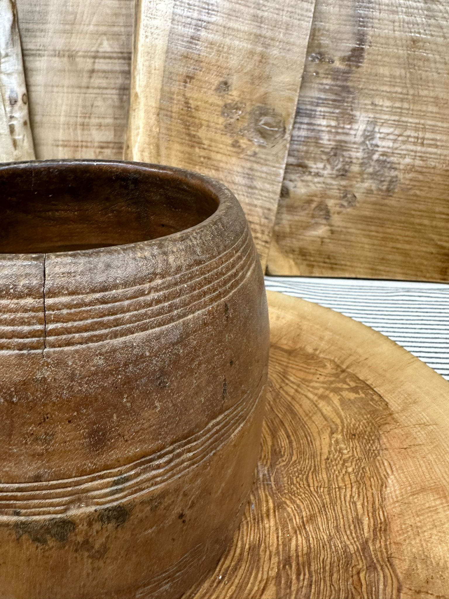 Rustic brown ceramic wooden vintage herb plant pot with horizontal ridges and a crack near the rim for desk tidy use