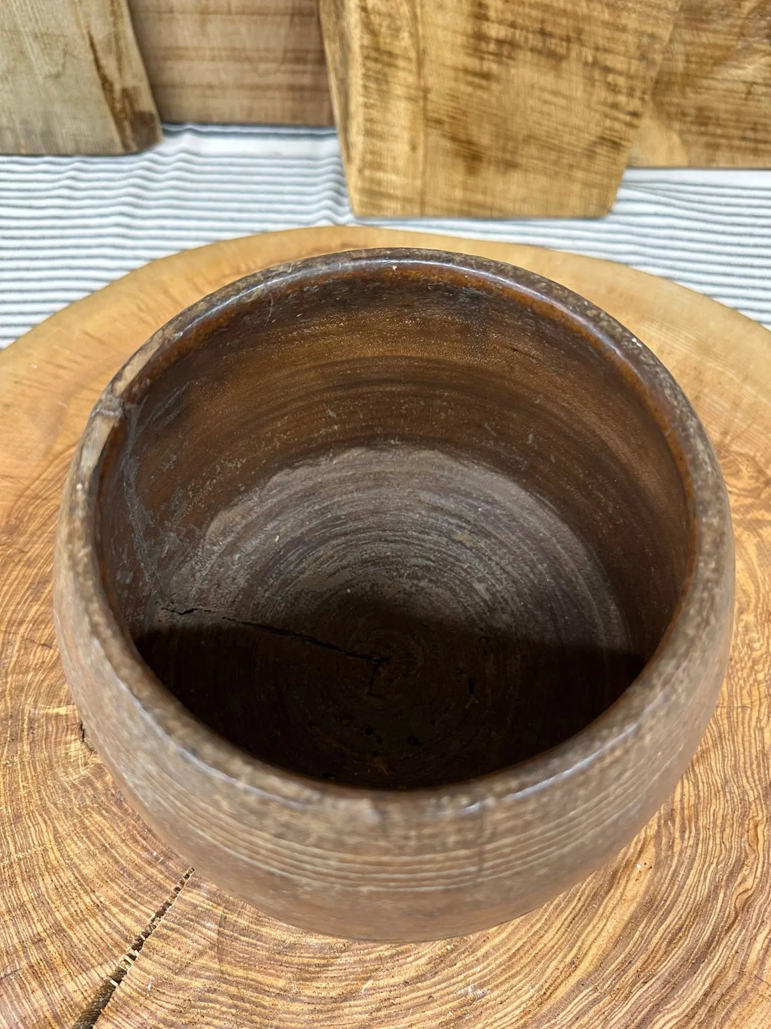 A rustic dark brown wooden vintage herb plant pot with visible grain and a slightly chipped rim for desk tidy use
