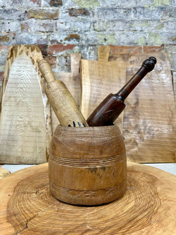 Antique wooden vintage herb plant pot planter with a round bowl and two pestles in light and dark brown wood