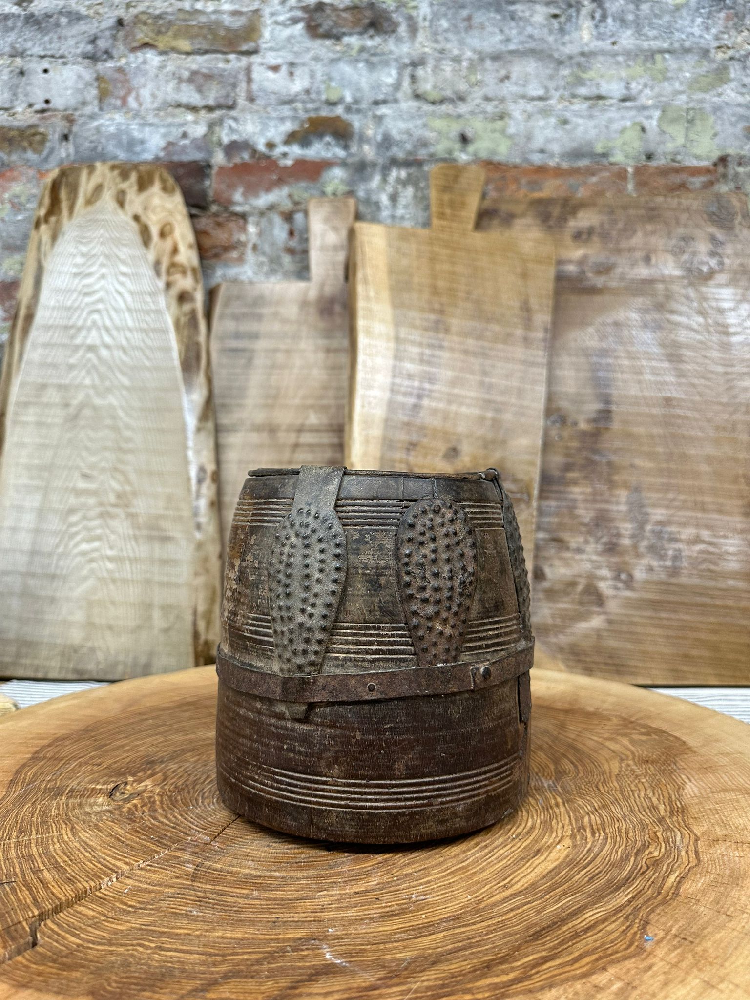 Dark brown hand carved wooden vintage bucket with geometric patterns and metal bands for herb planter or desk tidy