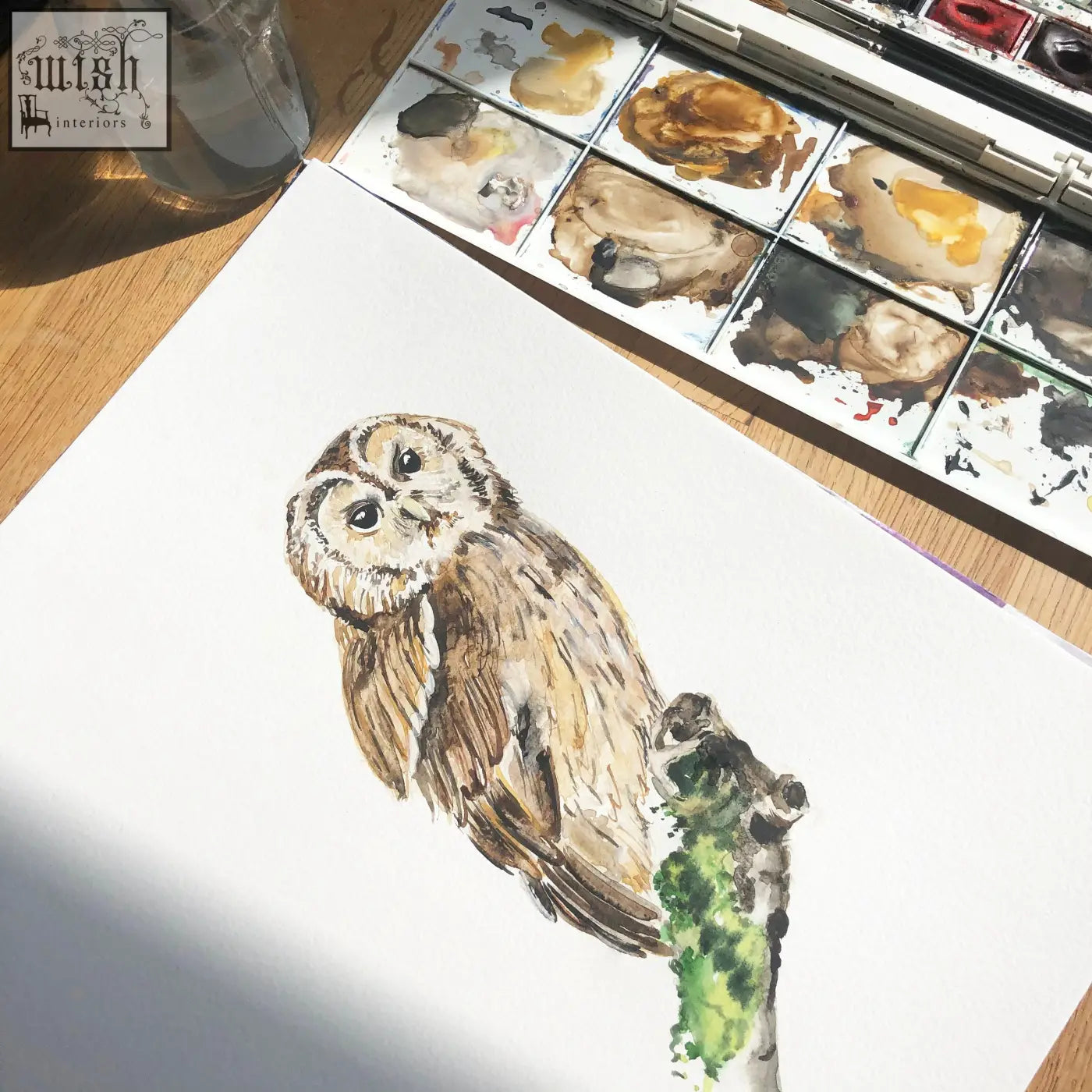 A watercolor mural wallpaper by artist katie of a brown and white owl on a green branch printed on 180gsm non-woven material