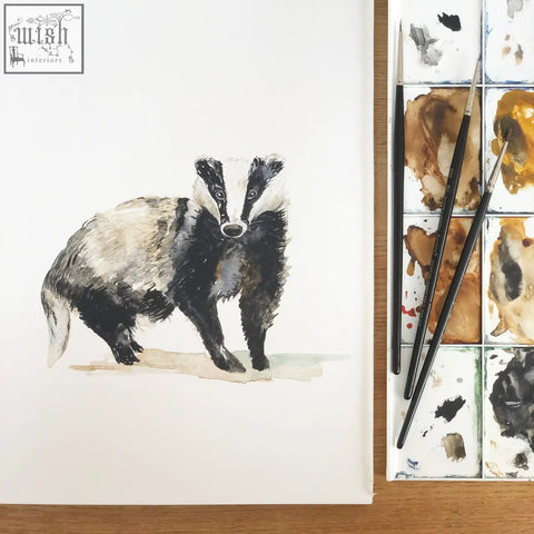 A 52cm pattern woodland animals childrens wallpaper featuring a soft watercolor badger with black and white fur on paper