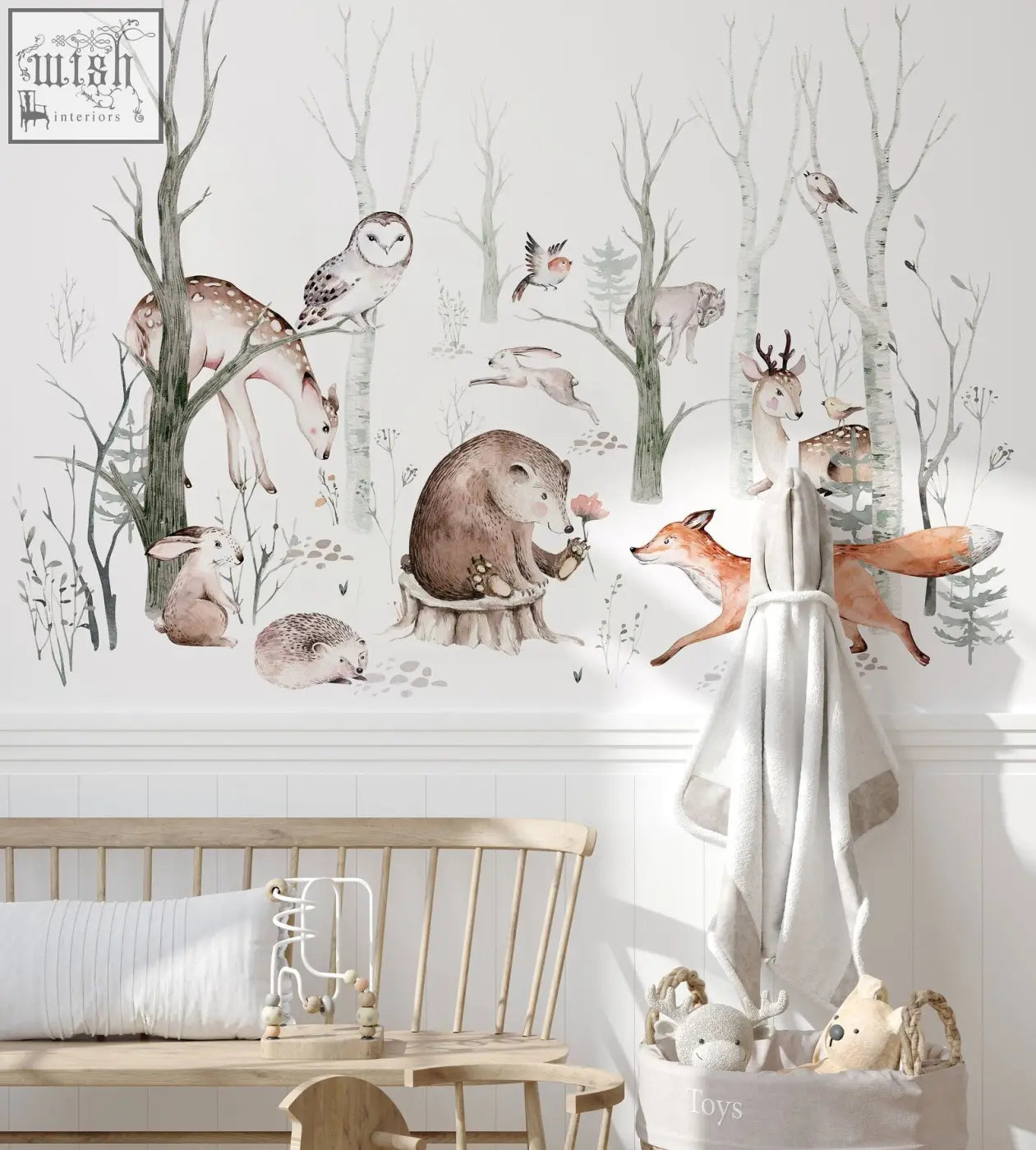 A soft off-white towel with gray trim hanging on a wooden rack near woodland forest wall decals for kids