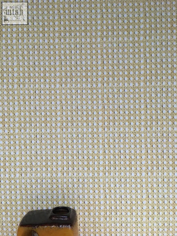 Beige woven cane wallpaper with a mesh texture and small circular holes for a stylish woven cane effect