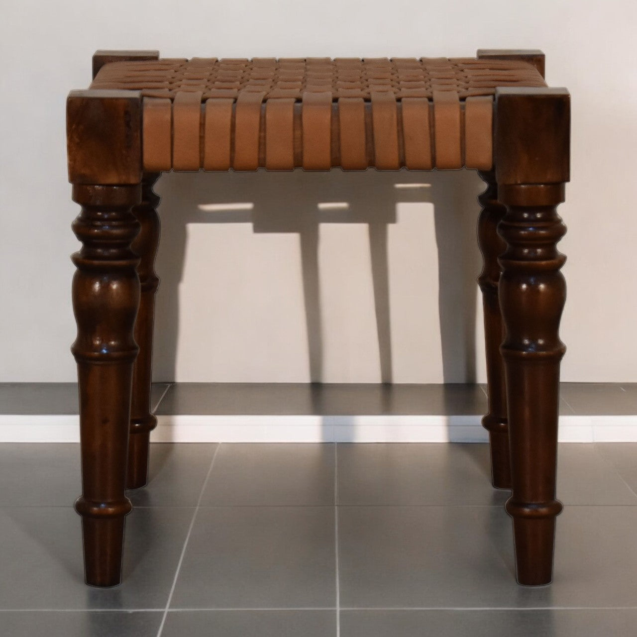 Woven leather footstool with brown leather-wrapped turned legs and woven seat made from chestnut solid mango wood
