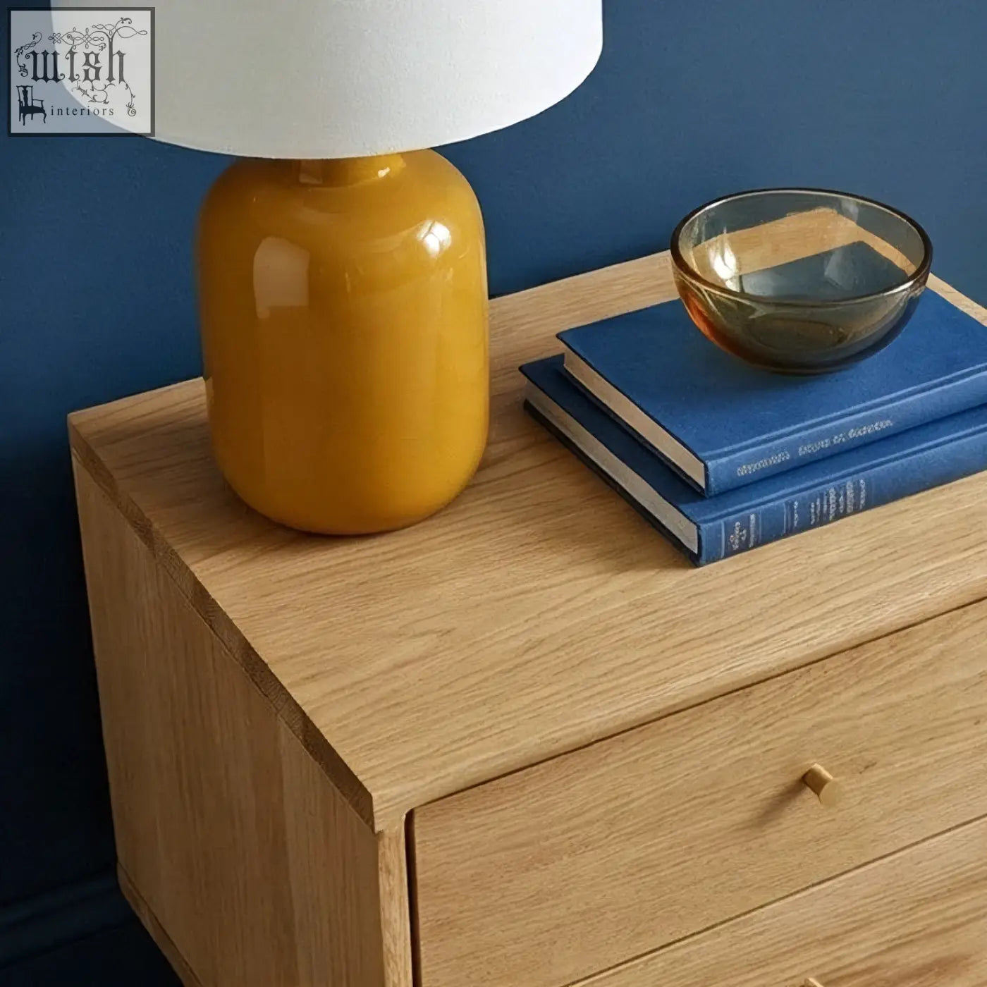 Vibrant yellow ceramic table lamp with white shade on solid oak wright oak bedside table for cozy lighting