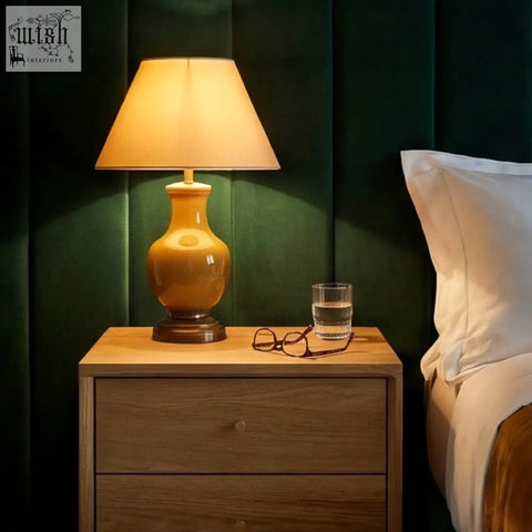 Warm amber ceramic table lamp with soft beige fabric shade on solid oak wright oak bedside table oak bedside